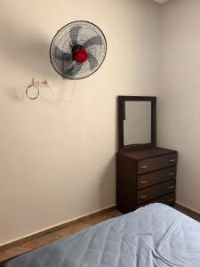 a bedroom with a bed and a dresser and a fan at Jaouhar immo in Martil +3 photos