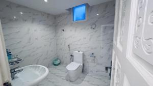a white bathroom with a sink and a toilet at Family Beach Villas in Salalah +13 photos