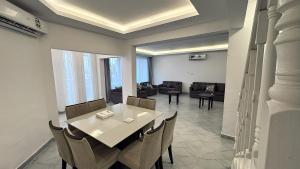 a dining room with a table and chairs and a living room at Family Beach Villas in Salalah
