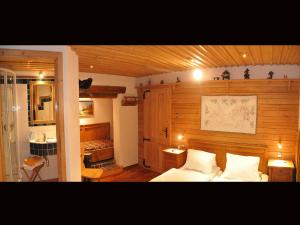a bedroom with a bed with a wooden wall at Romantikappartement Petz**** in Donnersbachwald