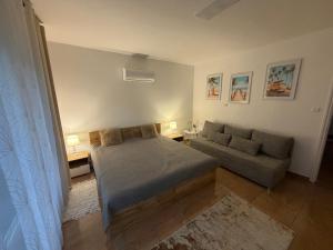 a bedroom with a bed and a couch at Fifteenapartman in Balatonföldvár
