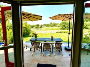 a patio with a table and chairs and umbrellas at 5 - Persons Lakeside 41 Bungalow in Ewijk
