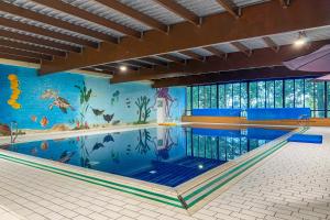 a large swimming pool with a mural in a building at 5 - Persons Lakeside 41 Bungalow in Ewijk