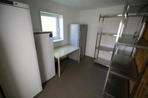 a small kitchen with a refrigerator and a window at Feriencamp Sibley - Gruppenhaus im Nationalpark Kalkalpen in Laussa +8 photos