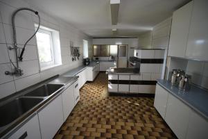 a large kitchen with white cabinets and a checkered floor at Feriencamp Sibley - Gruppenhaus im Nationalpark Kalkalpen in Laussa