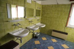 a bathroom with three sinks and two mirrors at Feriencamp Sibley - Gruppenhaus im Nationalpark Kalkalpen in Laussa