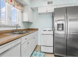 a kitchen with a stainless steel refrigerator and a sink at MarzyMagic Oceanview's in Myrtle Beach +4 photos