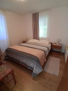a bedroom with a large bed with a window at Pet friendly Apartments Licul in Rabac
