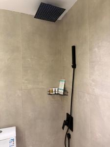 a bathroom with a shower with a light on the wall at سويت إبرام- بتصميم فاخر بدخول ذاتي in Dammam +23 photos