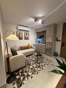 a living room with a couch and a kitchen at سويت إبرام- بتصميم فاخر بدخول ذاتي in Dammam