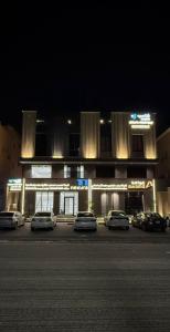 a building with cars parked in a parking lot at night at سويت إبرام- بتصميم فاخر بدخول ذاتي in Dammam