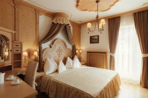 a bedroom with a large bed and a table at Hotel Colbricon in San Martino di Castrozza