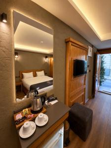 a hotel room with a bed and a table with plates at Ber Mai İnci Hotel Antalya in Antalya