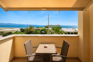 a table and chairs on a balcony with a view of the beach at Villa Maria Luisa in Cagliari