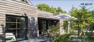 a house with sliding glass doors in a yard at Les Gîtes Ar Milin in Cordemais