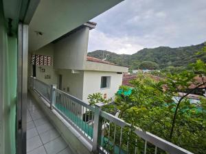 a balcony of a house with a view of the mountains at Acomodação Recanto do Sameiro in Mongaguá