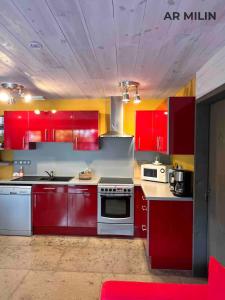 a kitchen with red cabinets and a stove at Les Gîtes Ar Milin in Cordemais +16 photos