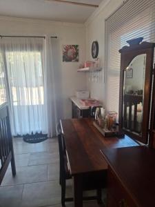 a dining room with a wooden table and a mirror at Protea in Britannia Bay