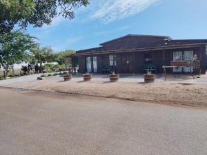 a house with potted plants in front of it at Protea in Britannia Bay