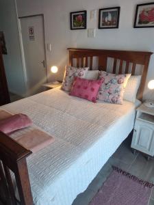 a bedroom with a large bed with pink pillows at Protea in Britannia Bay
