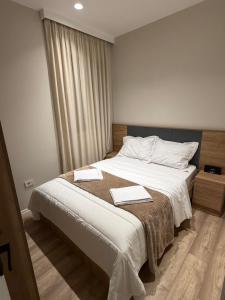 a bedroom with a bed with two towels on it at Villa Reger in Lalëz +25 photos