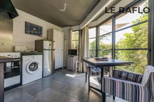 a kitchen with a refrigerator and a table with chairs at Les Gîtes Ar Milin in Cordemais