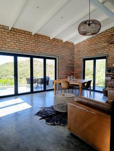 a living room with a brick wall and a table at Exhale Cottage in Montagu
