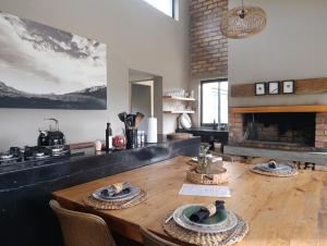 a dining room with a table and a fireplace at Exhale Cottage in Montagu +28 photos