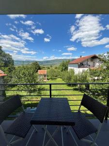 a table and chairs on a balcony with a view at Apartman Promaja in Široki Brijeg
