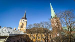 a church with a tall steeple and a building with a clock tower at White Palace in Riga