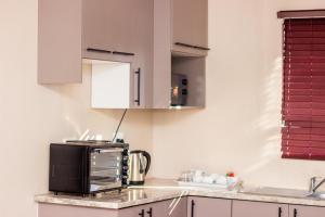 a kitchen with a microwave on top of a counter at Simlily Place in East London