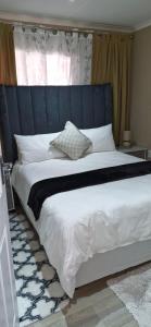 a bedroom with a large bed with a blue headboard at Simlily Place in East London