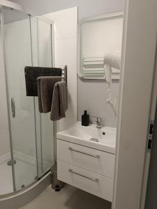 a white bathroom with a sink and a shower at Villa Antonina Apartamenty z aneksem in Czaplinek +16 photos