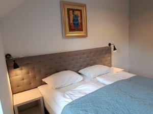 a bed with two pillows and a picture on the wall at Villa Antonina Apartamenty z aneksem in Czaplinek