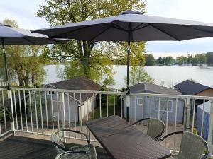 a deck with a table and chairs and an umbrella at Villa Antonina Apartamenty z aneksem in Czaplinek