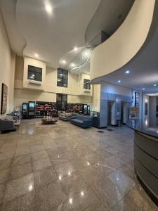 a large lobby with couches and tables in a building at Studio Aconchegante no Number One Flat com vista mar in São Luís