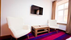 a room with two chairs and a tv and a table at White Palace in Riga +59 photos