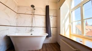 a white bath tub in a bathroom with a window at White Palace in Riga