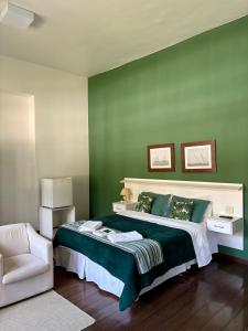 a green bedroom with a bed and a chair at Pousada Casa Imperatriz - Rua Teresa in Petrópolis +79 photos