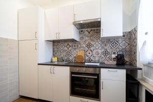 a kitchen with white cabinets and a stove top oven at La Porta Verde 8 - Relax vicino Parma in Collecchio