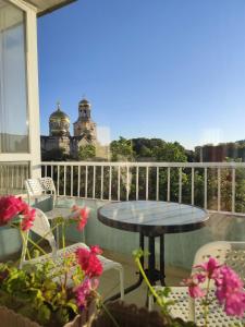 a patio with a table and chairs on a balcony at Grand and Prime Central Apartments Varna in Varna City