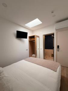 a bedroom with a bed and a television on the wall at B&B Berlenga 4 in Nazaré