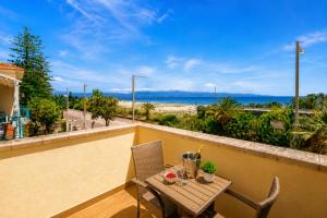 a table and chairs on a balcony with a view of the ocean at Villa Maria Luisa in Cagliari