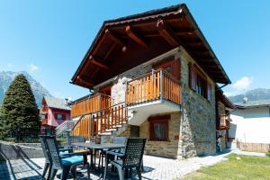 a house with a table and chairs in front of it at Casa Bruna Valmalenco, Casa vacanze sopra Caspoggio in Caspoggio