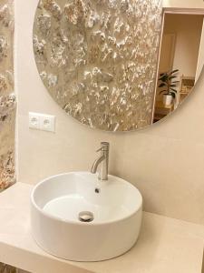 a white sink in a bathroom with a mirror at 70 sqm sea view apartment in Parga