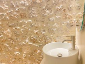 a white sink in a bathroom with a stone wall at 70 sqm sea view apartment in Parga