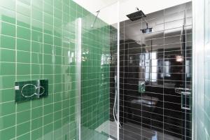 a green tiled bathroom with a glass shower at Vanity Suite in Sorrento +86 photos
