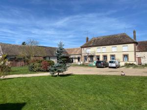 a house with two cars parked in a yard at Les Terres Noires in Serville