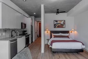 a bedroom with a king sized bed and a kitchen at Sentral Sol Modern in Phoenix