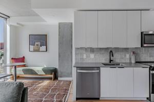 a kitchen with white cabinets and a living room at Sentral Sol Modern in Phoenix +40 photos